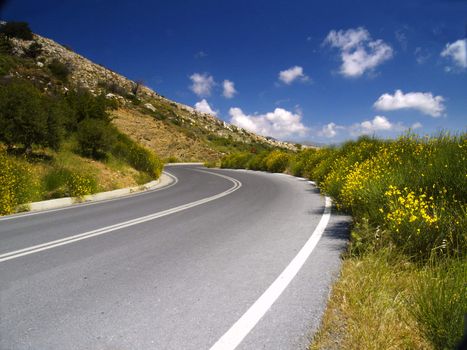 curvy road in cretan mountains on a bright sunny day