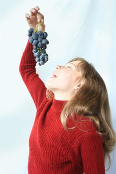The nice girl wishes to eat juicy grapes