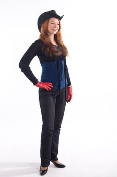 Young girl with red gloves and black hat standing on white background
