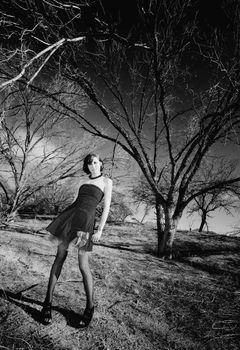 Punk fashion model in front of dead trees