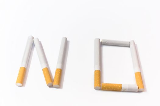 Word "not", laid out from cigarettes and photographed on a white background