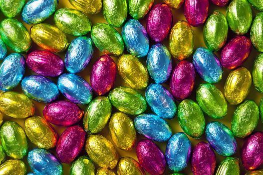 Colorful chocolate easter eggs for background. Top view, macro shot