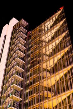 modern multi-storey office building of glass and steel at night