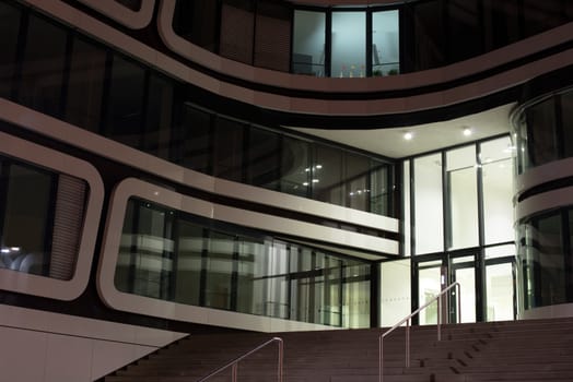 modern multi-storey office building of glass and steel at night