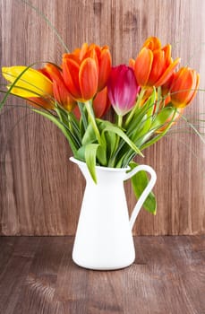 Bouquet of colorful tulips on dark wooden background