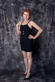 Beautiful adult woman in black dress. Studio shot