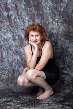 Beautiful adult woman in black dress. Studio shot