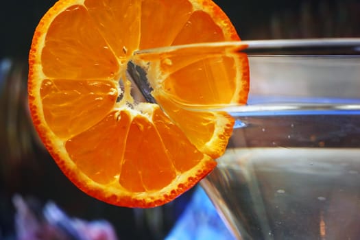 Glass with a plate orange on a dark blue background