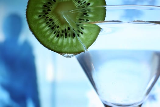 Glass with a plate kiwi on a dark blue background