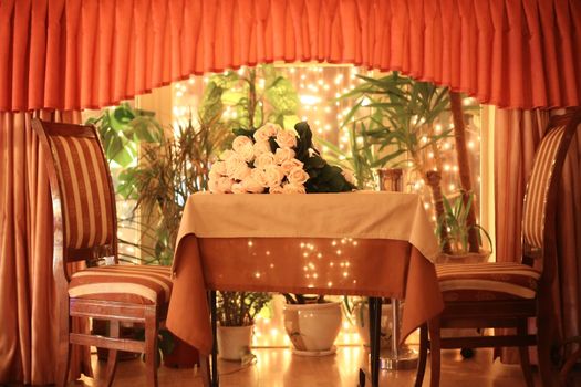 Bunch of fresh roses on a table in an interior of restaurant