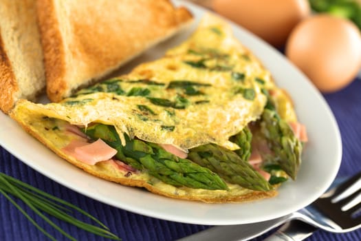 Green asparagus and ham omelet with toast bread (Selective Focus, Focus on the asparagus head in the front)