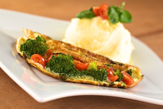 Broccoli and tomato omelette with mashed potato (Selective Focus, Focus on the broccoli floret in the front)