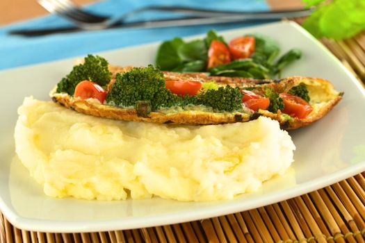 Broccoli and tomato omelette with mashed potato (Selective Focus, Focus on the broccoli and tomato in the middle of the image)