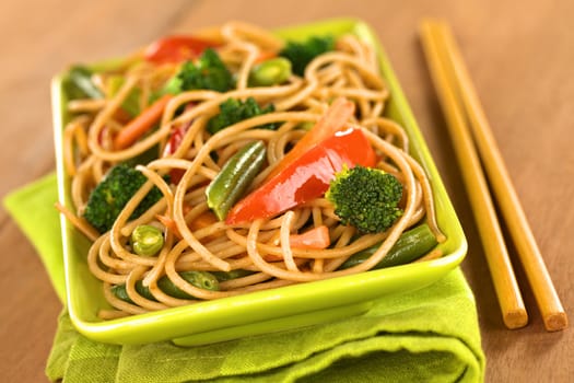 Vegetable and wholewheat spaghetti stir fry with chopsticks (Selective Focus, Focus on the broccoli floret in the front)