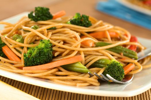 Vegetable and wholewheat spaghetti stir fry with fork (Selective Focus, Focus on the vegetables in the front)