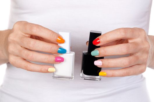 Closeup of a hand holding bottles with black and white nail polish