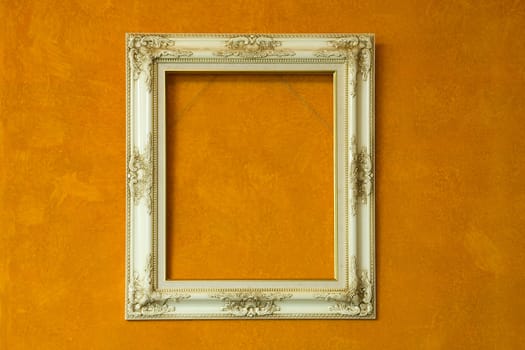Blank antique ivory frame on orange painting background