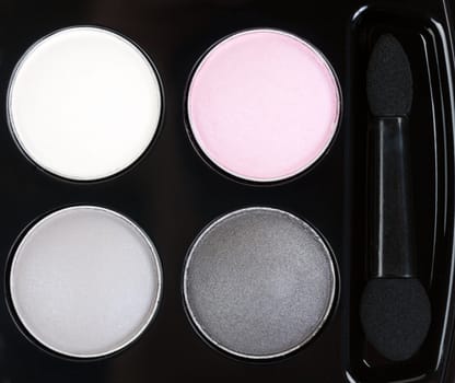 Set of four round eye shadow in a black plastic box