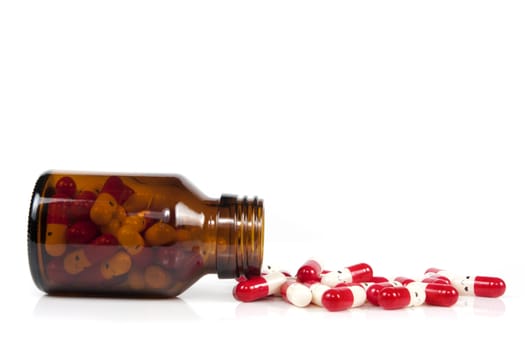 Open happy pill bottle with medicine spilling out of it isolated on white