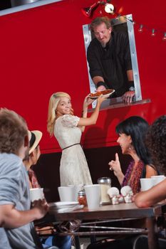 Pretty young woman picking up pizza order at food truck