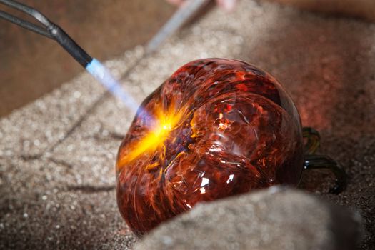 Blowtorch sealing up orange fine art glass piece