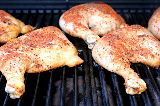 Spiced bbq chicken on the grill still raw.