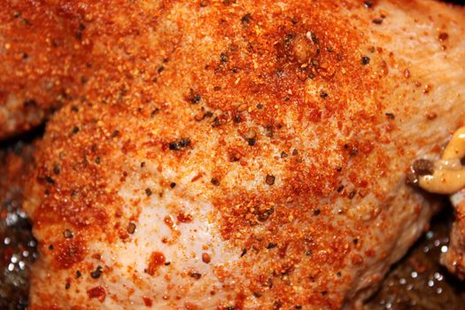 Closeup of chicken spiced with pepper and paprika.
