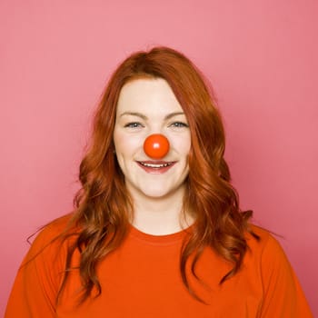 Woman with red hair on pink background