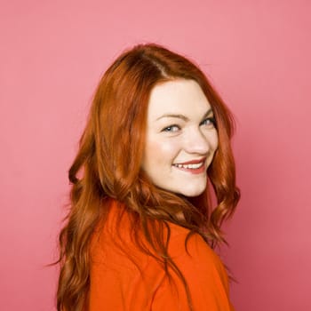 Woman with red hair on pink background
