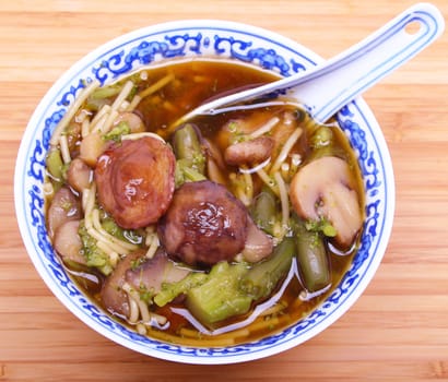 Closeup of vegetarian chinese soup with noodles and mushrooms