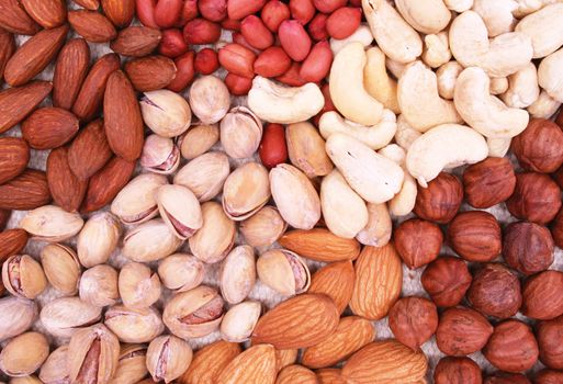 Assorted filbert, peanut, pistachios, almonds and hazelnuts on natural sackcloth 
