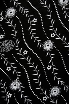 Black fabric with white flower pattern can use as background 