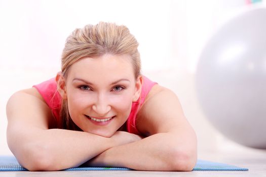 Young beautiful woman in fitness wear at home