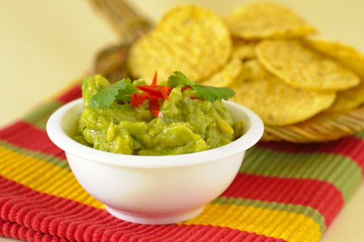Serving of freshly made guacamole served with chips.