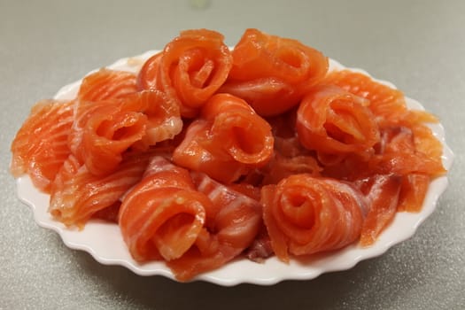 Pieces of salmon in the form of roses on a plate