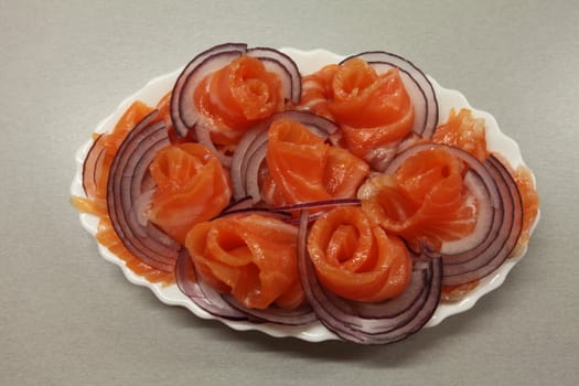 Slices of salmon with red onion on a plate
