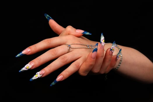 Human fingers with long fingernail and beautiful manicure isolated on black
