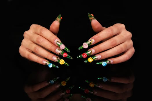 Human fingers with long fingernail and beautiful manicure isolated on black