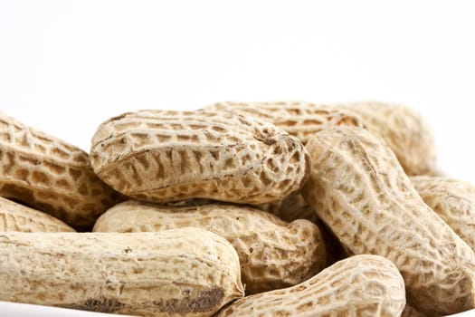 Peanut in shell snack on white plate - shallow DOF focus in the middle