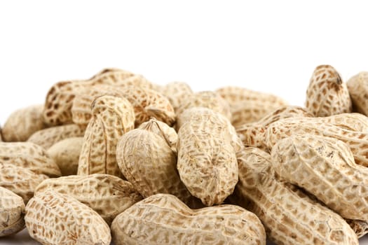 Peanut in shell snack on white plate - shallow DOF focus in the middle