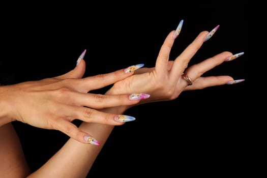 Human fingers with long fingernail and beautiful manicure isolated on black