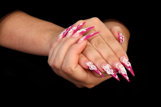 Human fingers with long fingernail and beautiful manicure isolated on black