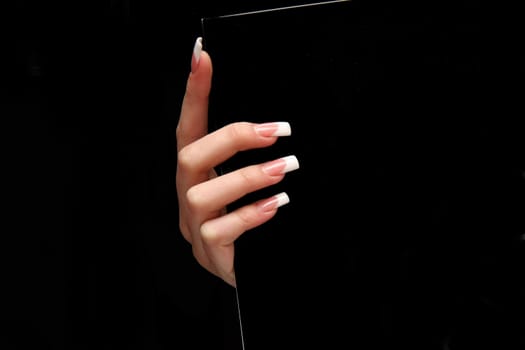 Human fingers with long fingernail and beautiful manicure isolated on black