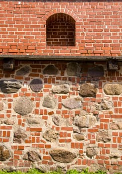 Architectural defence wall background. Ancient wall made of red brick and stones.