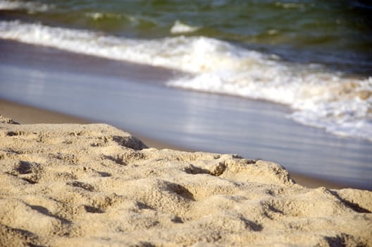 Sea sand on coast and waves out of focus. Natural background.