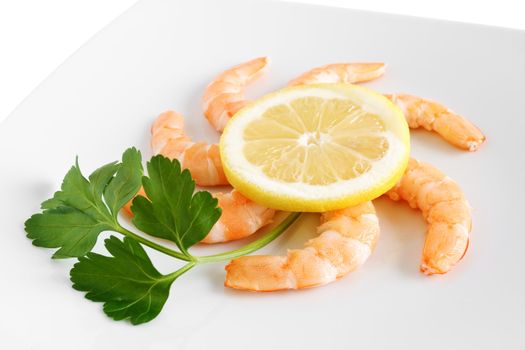 detail of shelled shrimps with lemon and parsley on a white plate