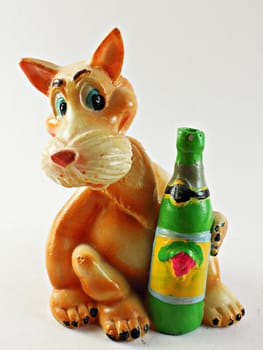 Toy ginger dog sits with green bottle