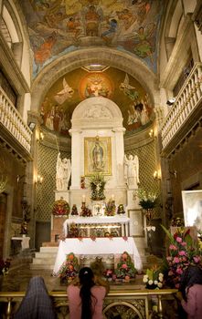 Praying at Guadalupe Church, Guadalupe Shrine, Mexico City, Mexico Capilla del Pocito  This Shrine is at the top of the hill where the Virgin Mary first appeared to Juan Diego in 1531.


