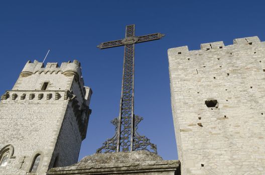 Christian cross between two medieval towers in France