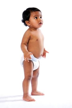 Cute baby toddler standing and looking amazed surprised up wearing diaper, childhood concept.